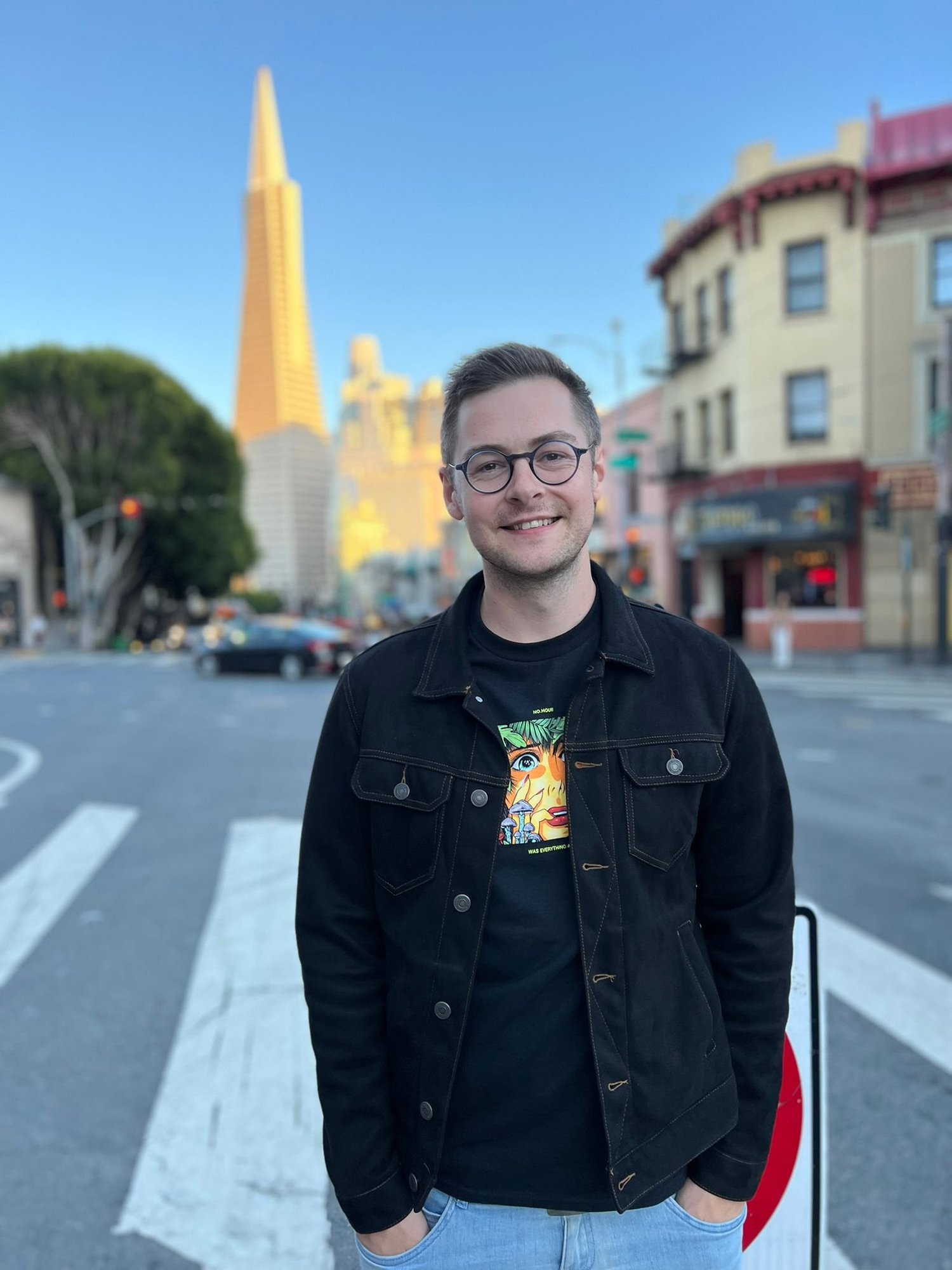 John Sunart, smiling, in a street scene.